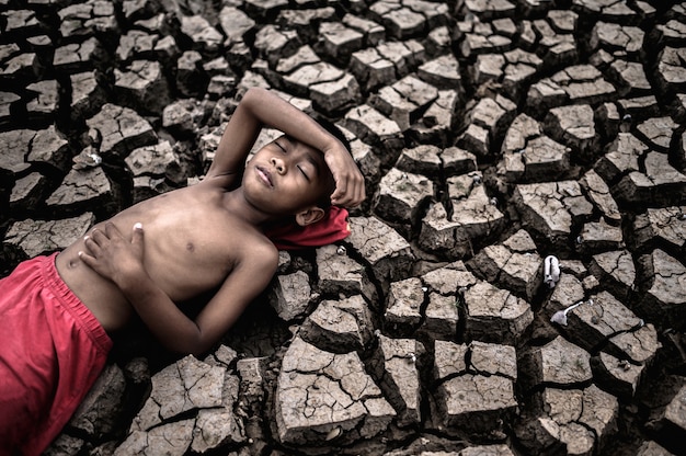 The boy lay flat, laying his hands on the belly and forehead on dry soil.