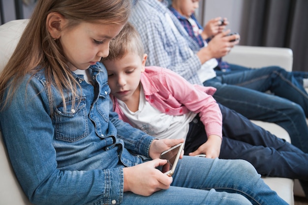 Boy looking at sister using smartphone