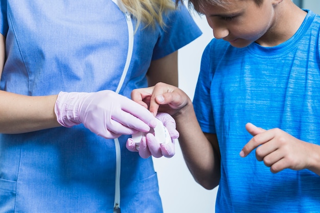 Free photo boy looking at teeth plaster mold hold by dentist