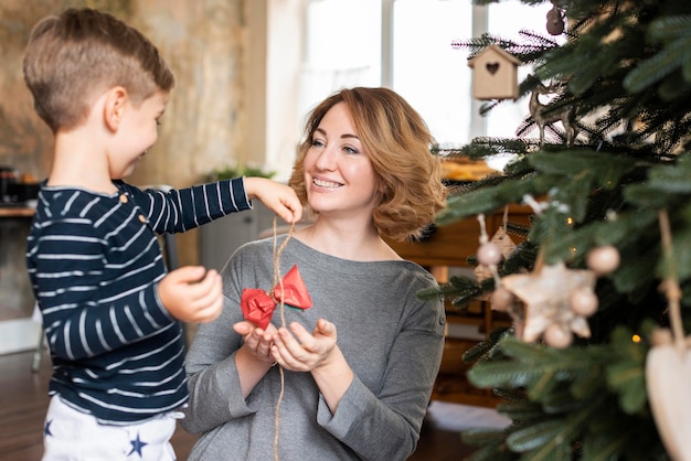 Boy and mother holding tree decoration