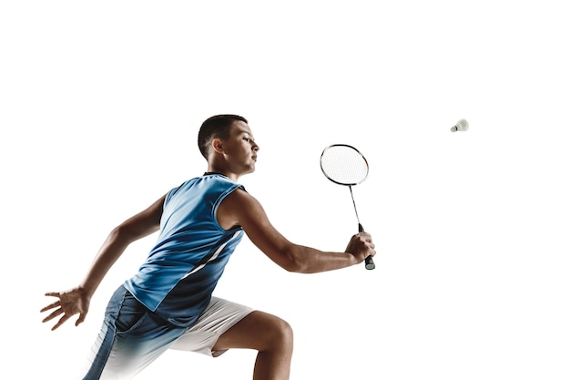 Boy playing badminton isolated on white wall.