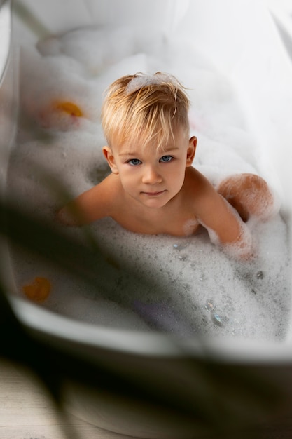 Boy playing in bathtub high angle