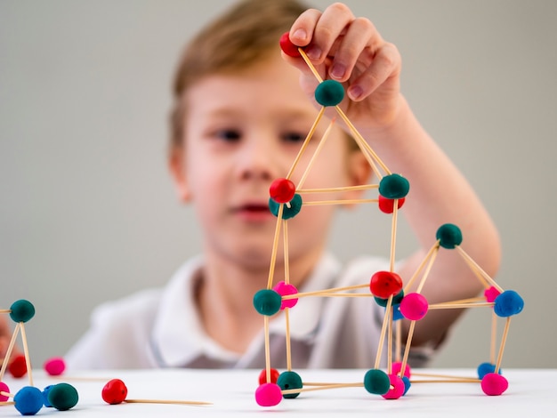 Free Photo boy playing with colorful atoms game on the table