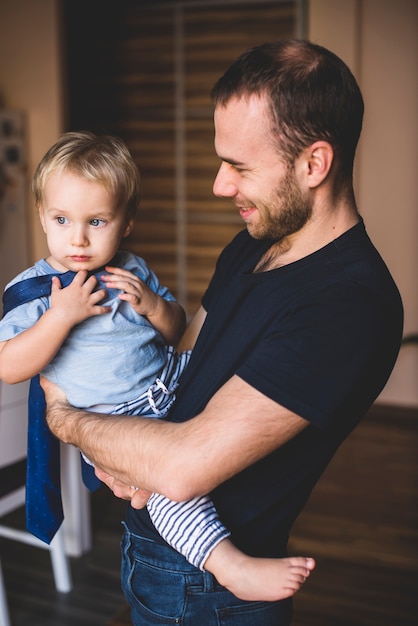 Free Photo boy playing with his father's tie