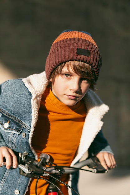 Free Photo boy posing with his bike outside in the city