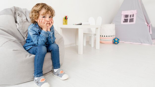 Boy sitting on sofa at home