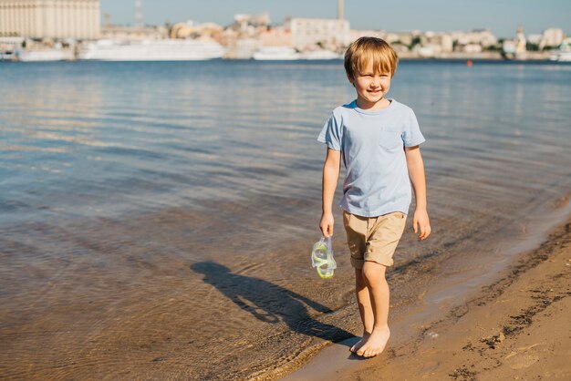 Boy walking along shore