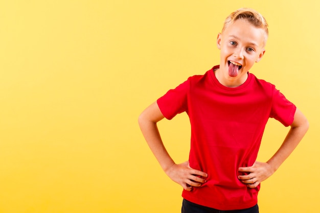 Boy with hands on waist showing tongue