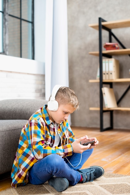 Boy with headphones using smartphone