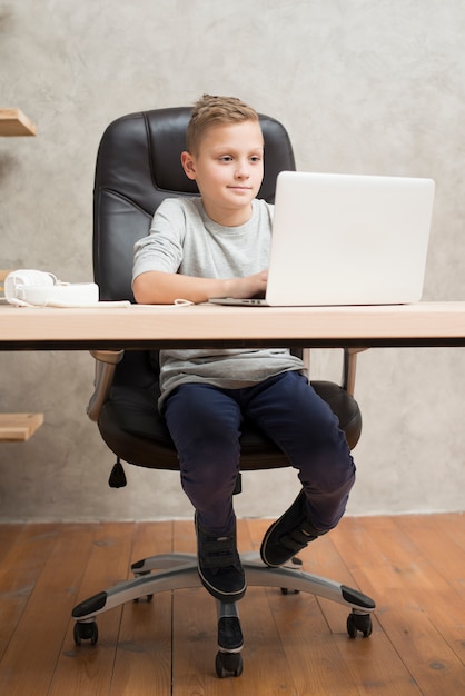 Boy with laptop in office