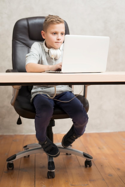 Boy with laptop in office