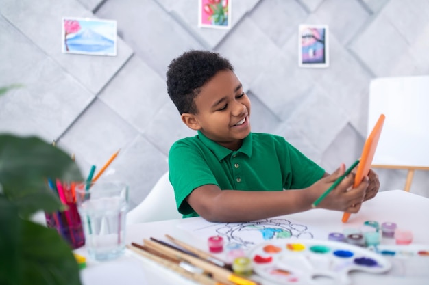 Boy with pencil looking into tablet