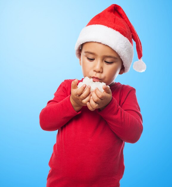 Boy with santa hat playing with snow