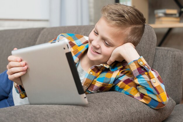 Boy with tablet on couch