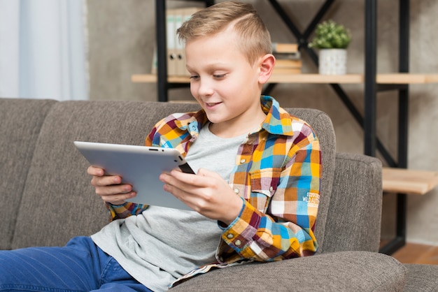 Boy with tablet on couch