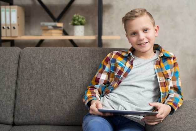 Boy with tablet on couch