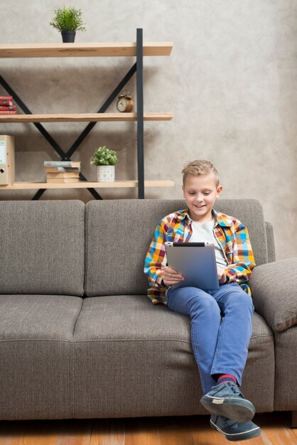 Boy with tablet on couch