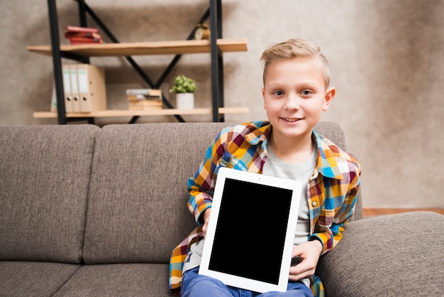 Free photo boy with tablet on couch