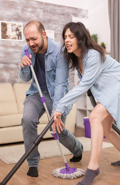 Boyfriend and girlfriend singing and cleaning the house