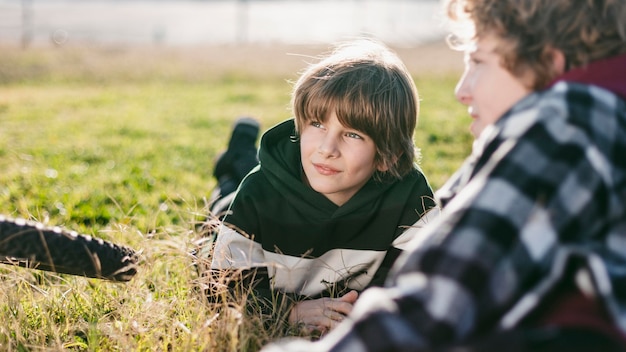 Boys resting on grass while riding their bikes