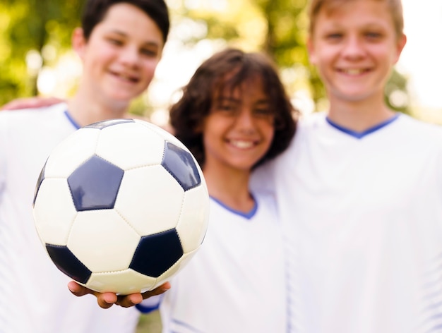 Boys in sportswear holding a football