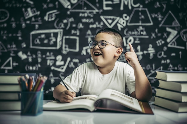 Free photo boys with glasses write books and think in the classroom