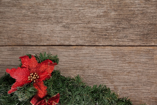 Free photo branch of a christmas tree with a red flowwer