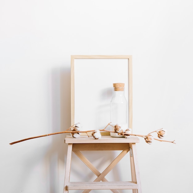 Free photo branch in front of frame on stool