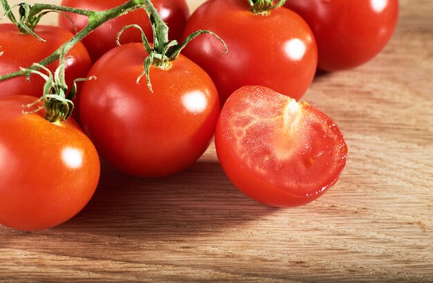 Branch of red cherry tomatoes organic wooden.