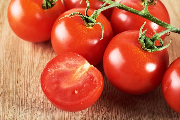 Branch of red cherry tomatoes organic wooden.