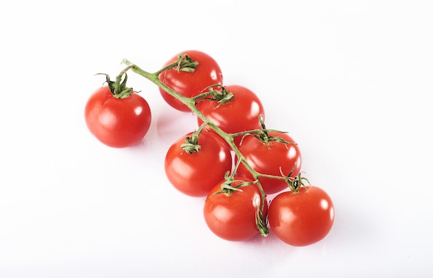 Branch of red organic tomatoes on a white.