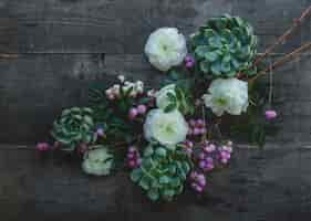 Free photo a branch of white and purple blossom flowers on a wooden table.