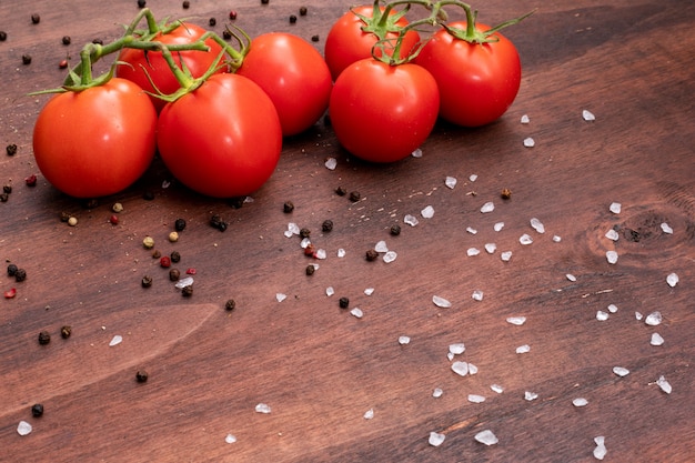 branches of tomato scattered salt and black pepper powder on brown stone