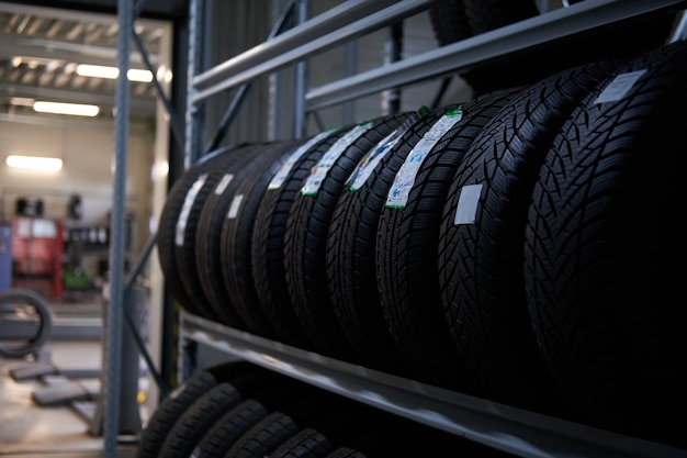 Free photo brand new big variety of car's tyres on shelf with prices at store or warehouse.