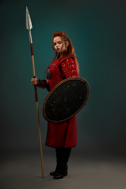 Free photo brave woman warrior with weapon posing in studio.