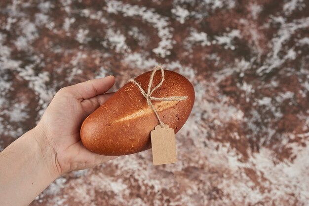 Bread bun on marble in the hand.