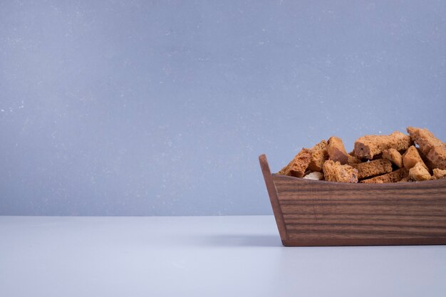 Bread crackers in a wooden tray on blue