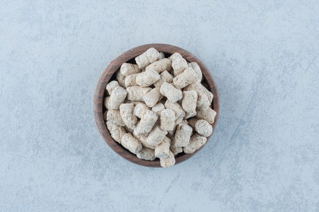 Bread crumbs in the bowl next to spike on marble.