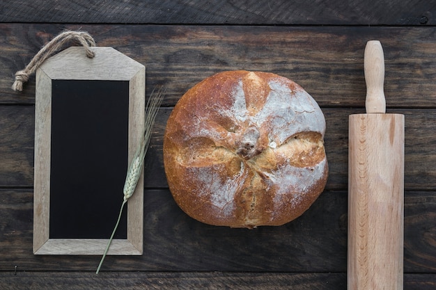 Free Photo bread between rolling pin and blackboard