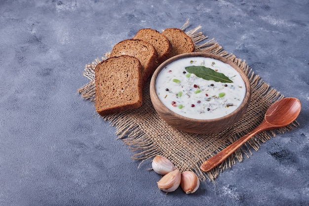 Free photo bread slices with a cup of yogurt soup and garlics.