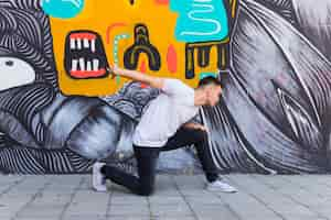 Free photo breakdancer dancing on painted wall background