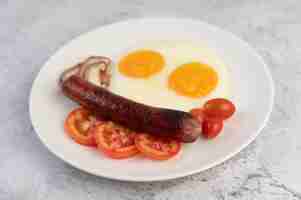 Free photo breakfast consisting of bread, fried eggs, tomatoes, chinese sausage and mushrooms.