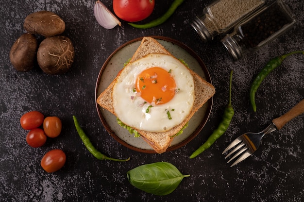 Free Photo breakfast sandwich made with bread, fried egg, ham, and lettuce.