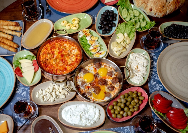 Breakfast set with scrambled eggs, olives, white cheese, cucumbers, tomatoes and tea