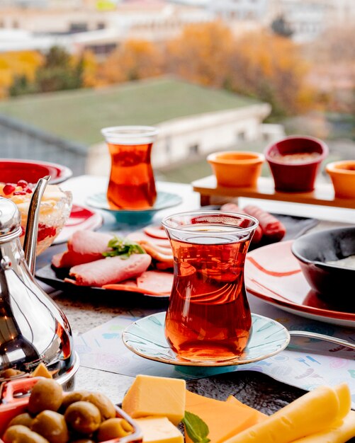 Breakfast set with tea sliced cheese olives and sausages