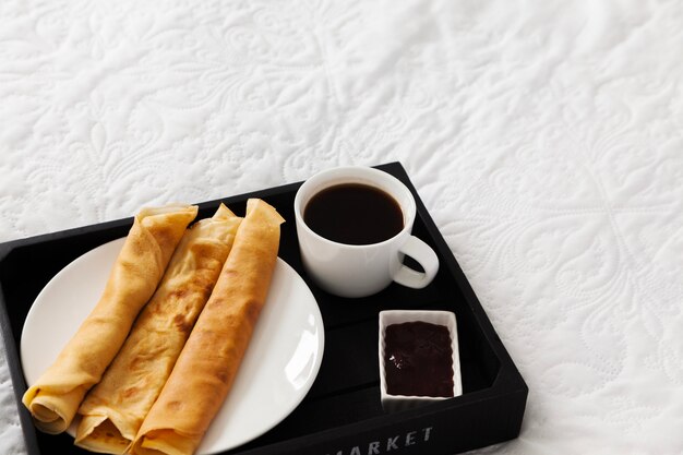 Breakfast tray with coffee, pancakes and syrup