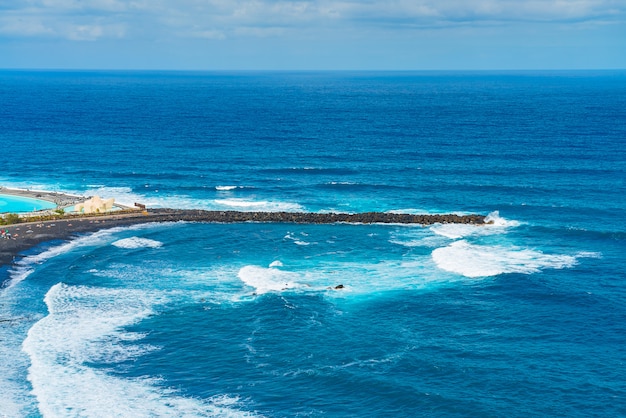 Free photo breakwater of beach with black sand. playa de martianez, puerto de la cruz, tenerife, spain