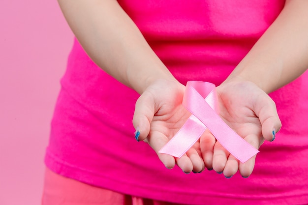 Free photo breast cancer awareness , pink ribbon placed on both handswomen is a symbol for world breast cancer day.