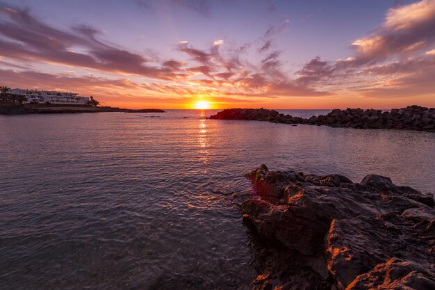 Breathtaking scenery of the beautiful sunset and the colorful cloudy sky reflected in the sea