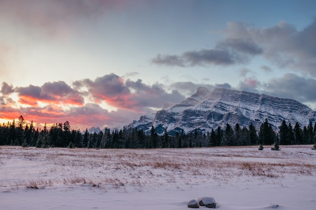 Free photo breathtaking scenery of a mountainous landscape covered with snow under the beautiful sunset sky